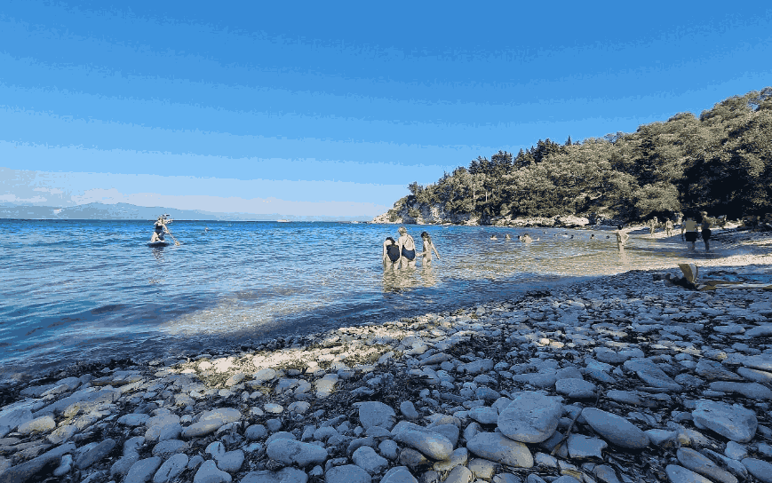 Plaža Paksija Marmari — beli šljunak i nudistička tradicija